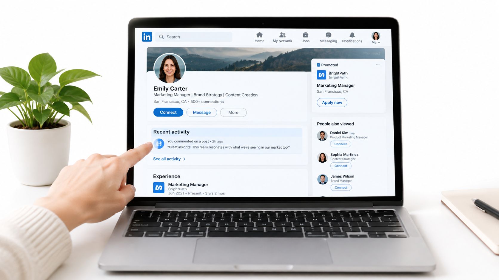 A person pointing at a LinkedIn profile page on a laptop screen displaying professional networking content.