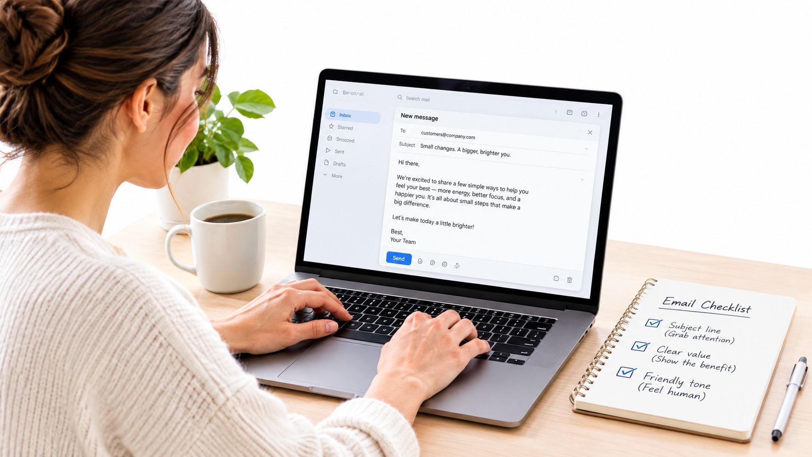 A woman working on a laptop computer drafting a professional marketing email with a physical checklist nearby.