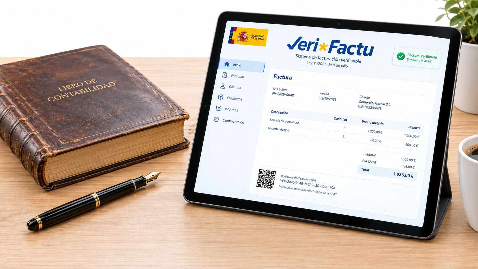 Tableta mostrando una factura digital VeriFactu junto a un libro de contabilidad antiguo y una pluma estilográfica.