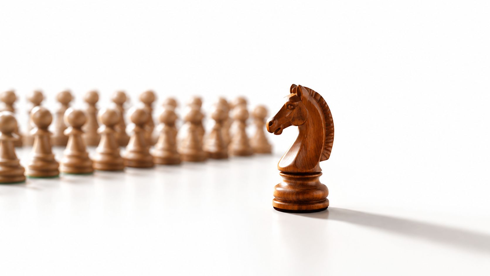 A wooden chess knight stands in front of a blurred background of multiple chess pawns.