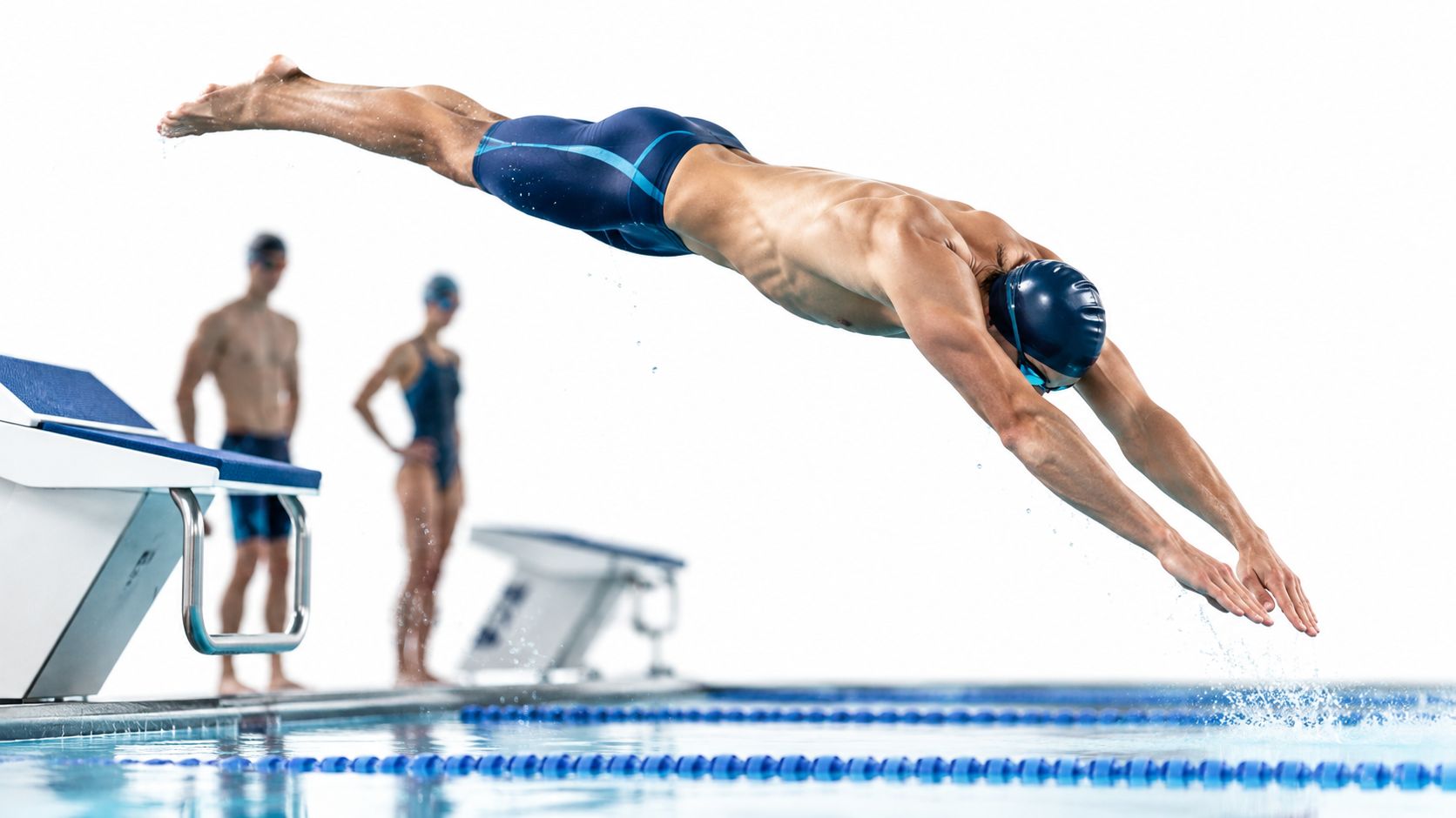 Nadador masculino realizando un salto de competición desde el bloque de salida hacia la piscina olímpica.