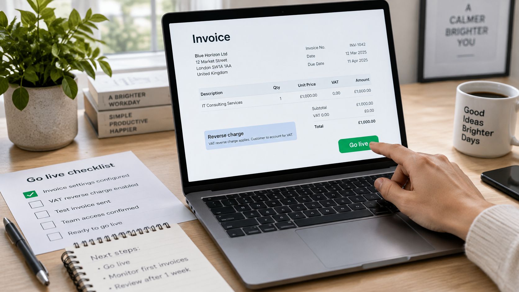 A person using a laptop to review an invoice with reverse charge VAT settings enabled for business.