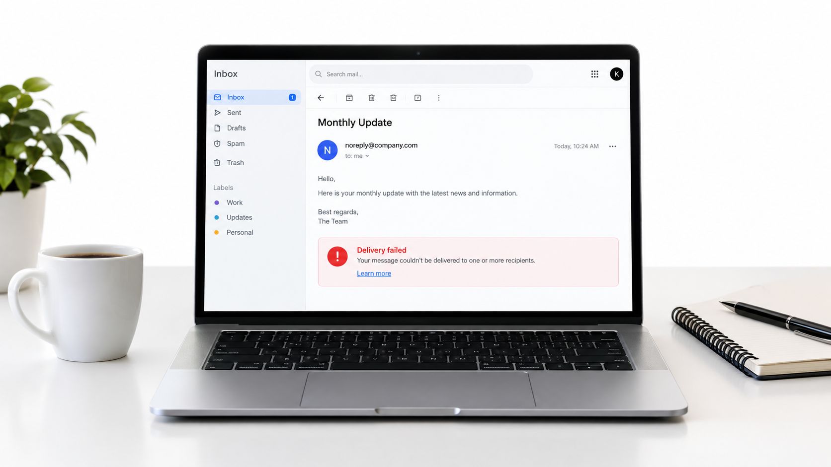 A laptop screen showing a failed email delivery notification in an inbox on a clean white desk.