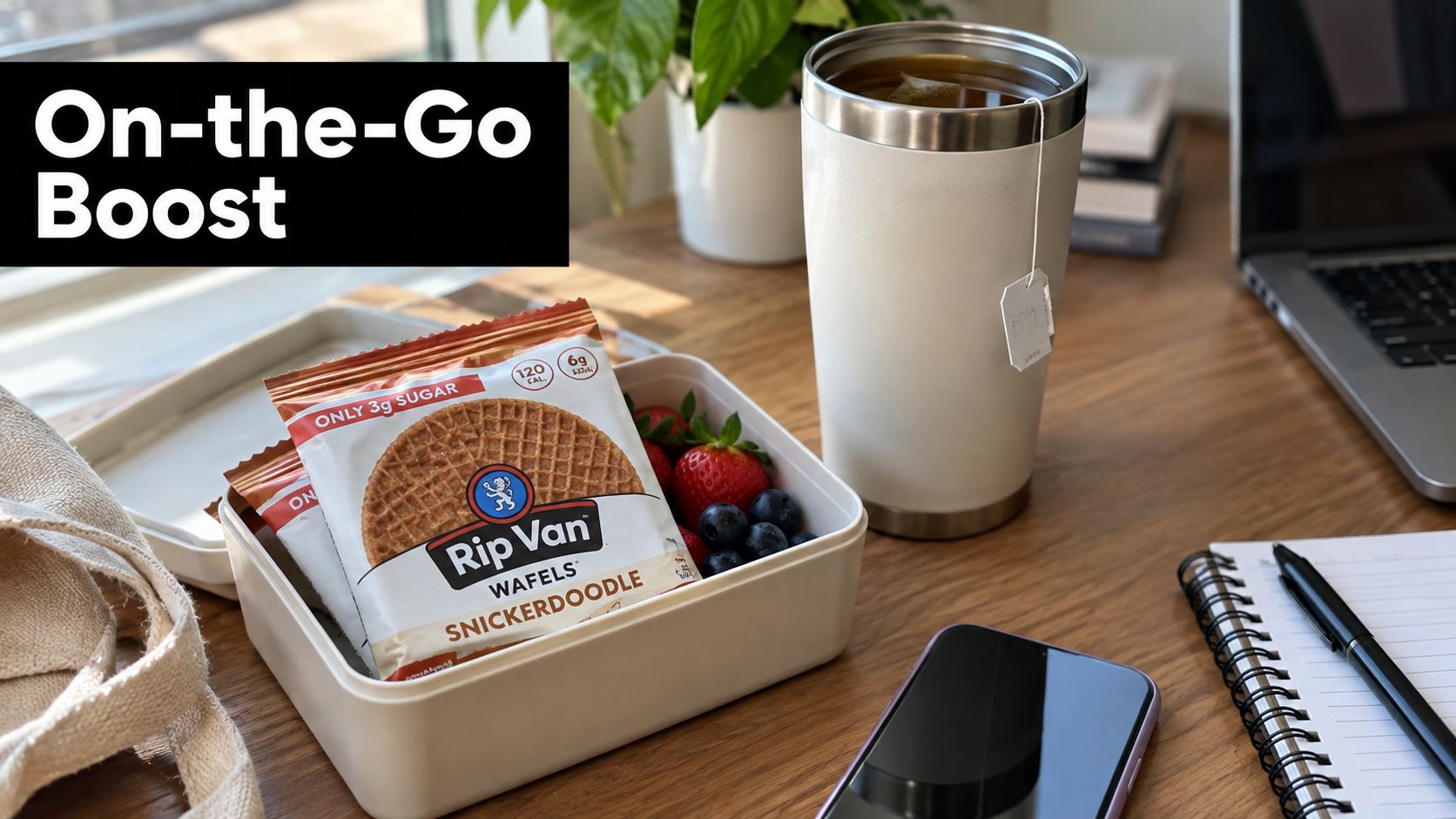 A lunch box containing Rip Van snickerdoodle wafels and fresh berries next to a tea tumbler.