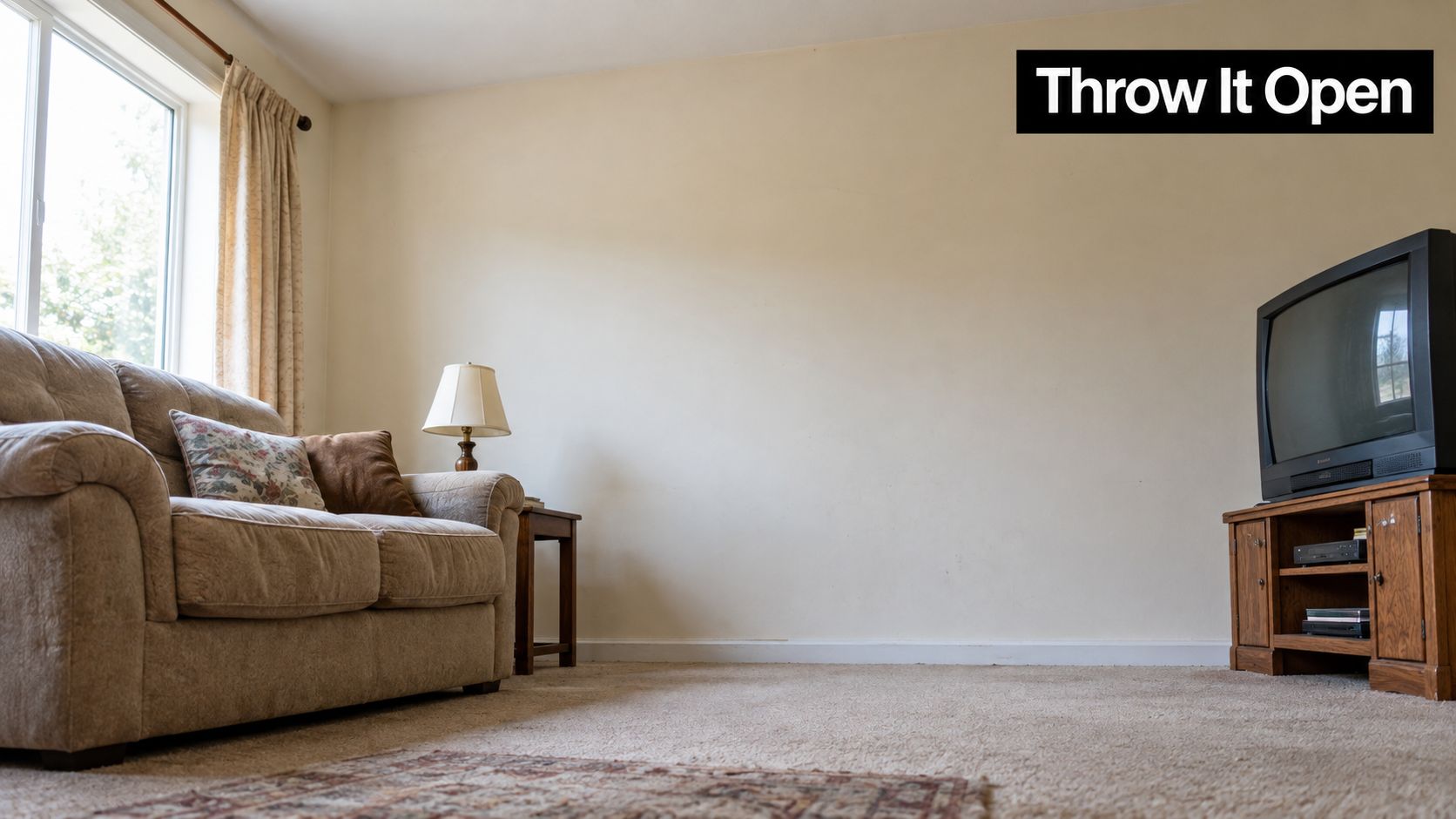 A cozy living room featuring a tan couch, a side table with a lamp, and a television.
