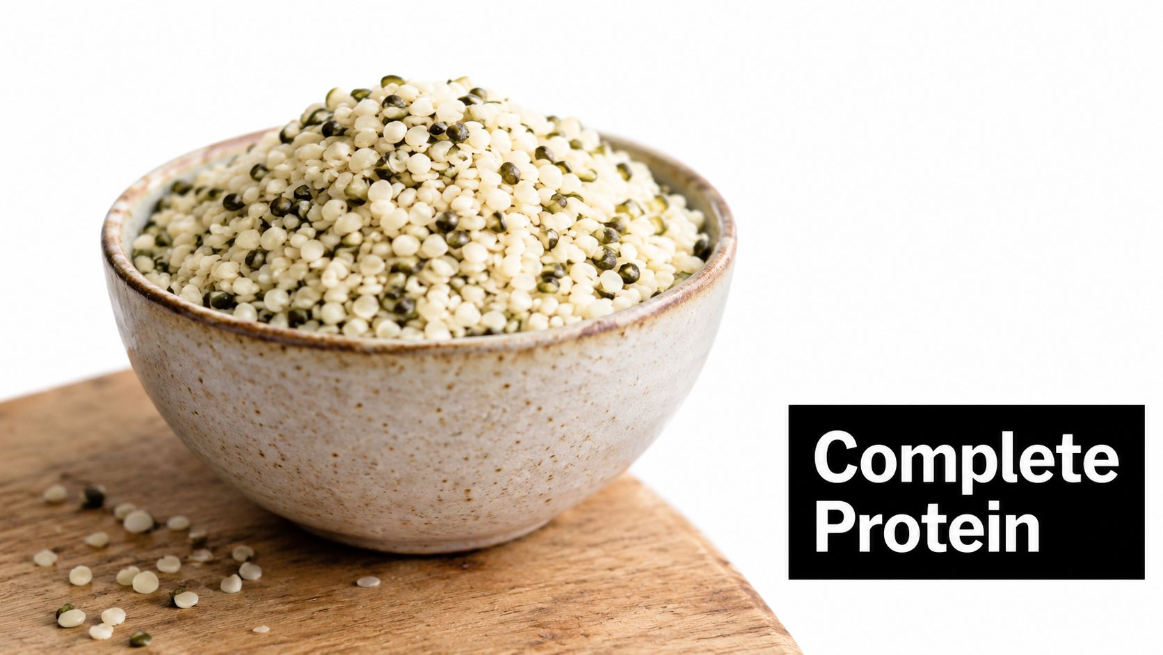 A ceramic bowl filled with raw hemp seeds sitting on a wooden cutting board, white background.