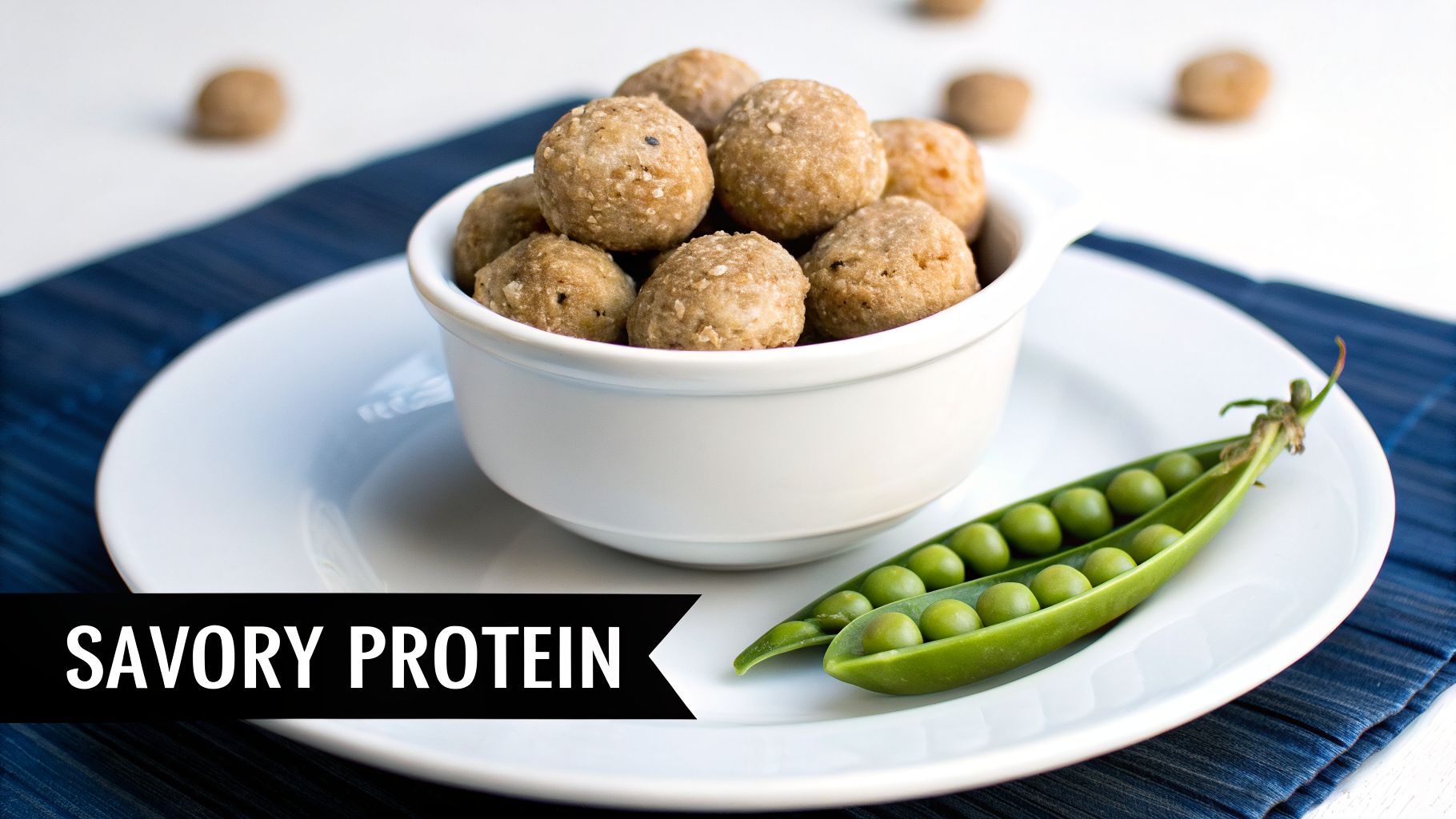 A white bowl of savory protein balls with fresh green peas on a white plate.