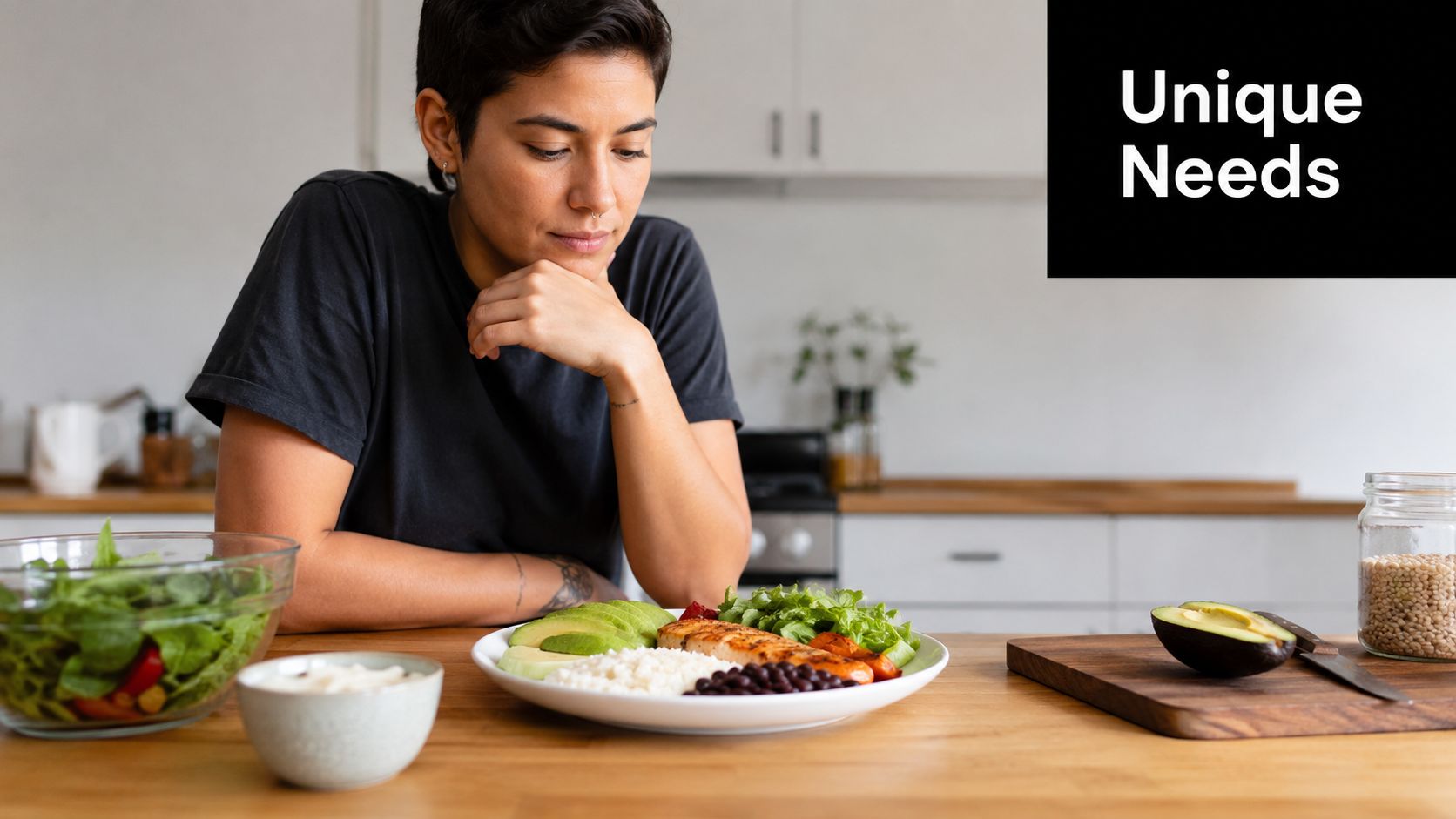 A person looks thoughtfully at a balanced, healthy meal of protein, grains, and vegetables at a kitchen table.