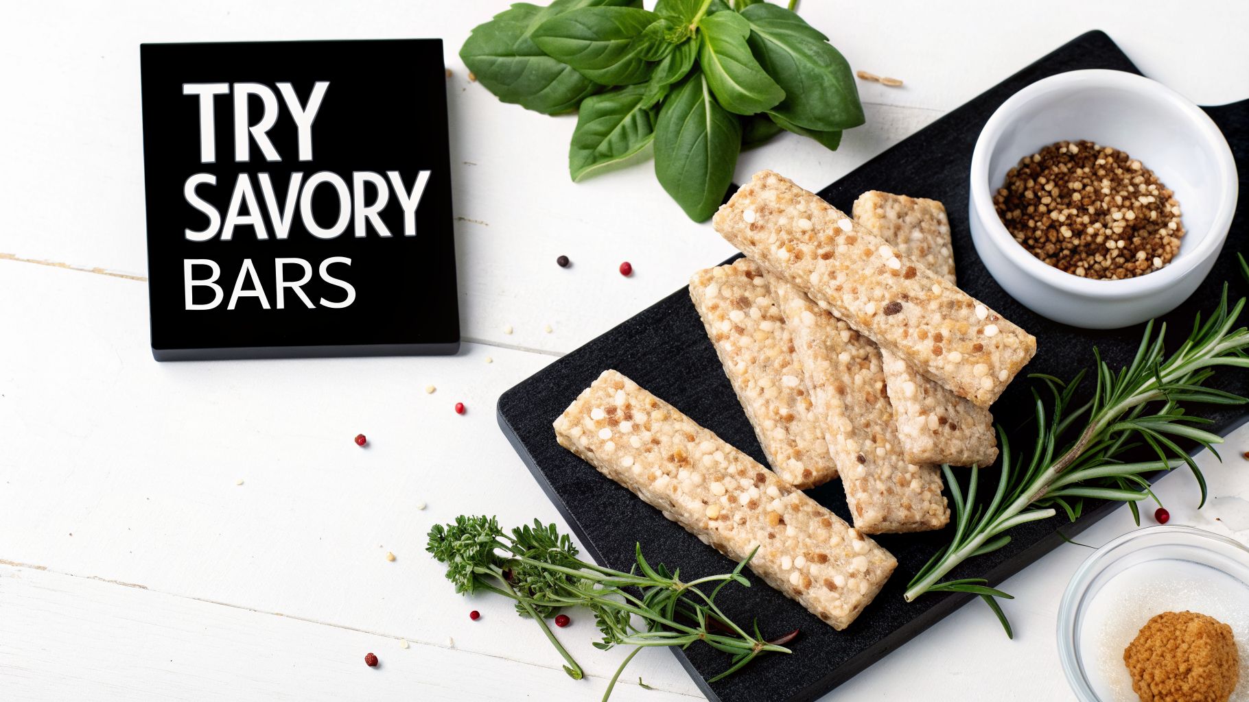 Savory grain bars displayed on a black board with fresh herbs, seeds, and a 'Try Savory Bars' sign.