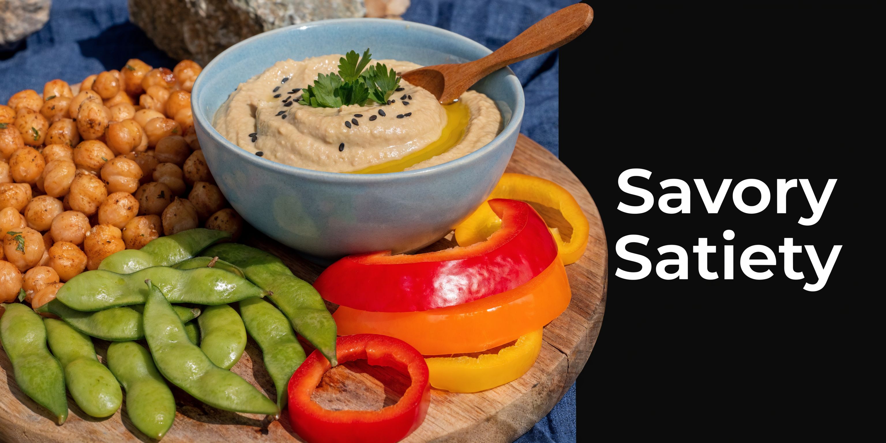 A healthy snack platter featuring a bowl of creamy hummus, roasted chickpeas, edamame, and colorful bell peppers.