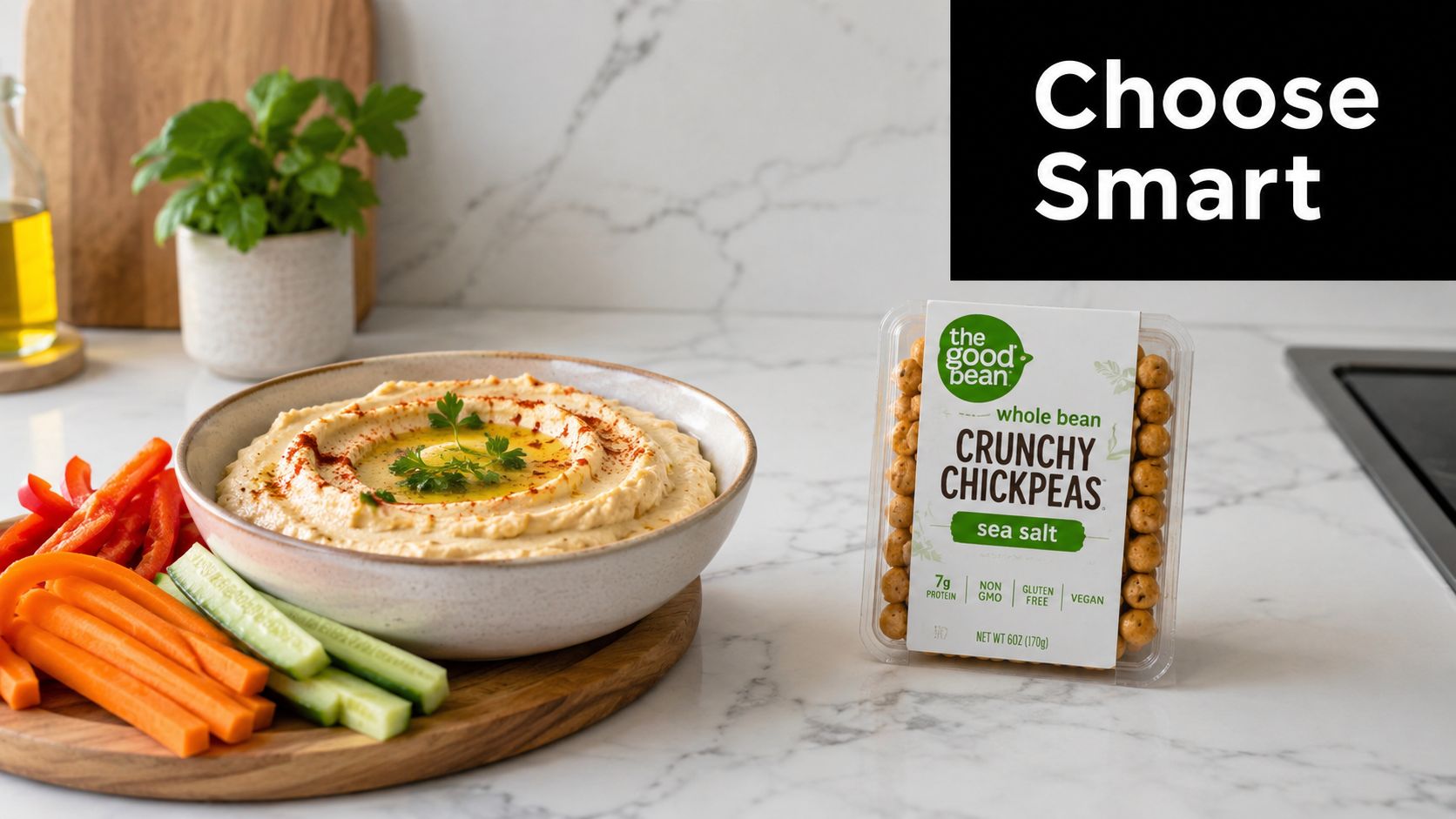 A bowl of hummus with fresh vegetables and a package of The Good Bean crunchy chickpeas.