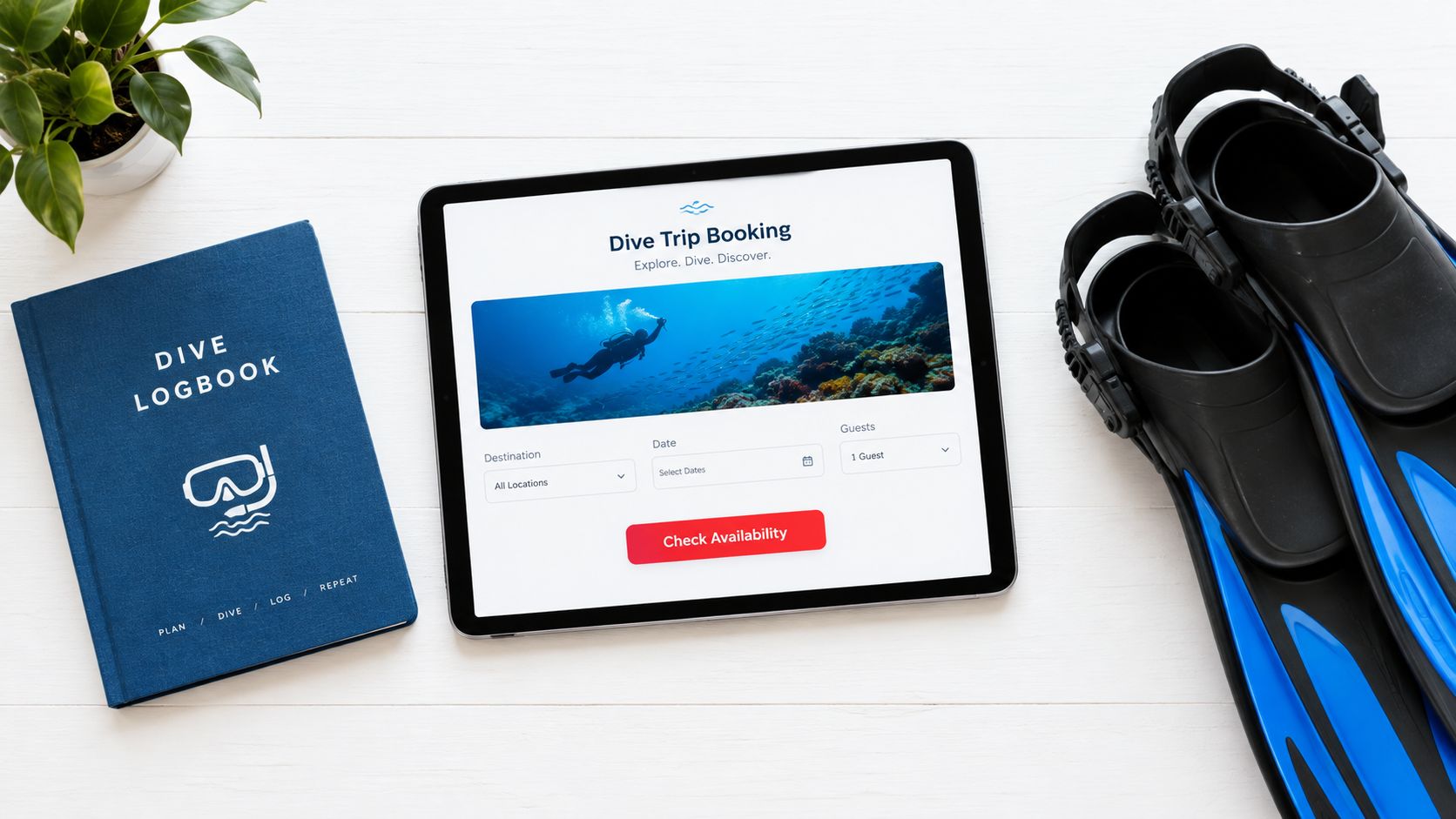 An overhead view of a dive logbook, swim fins, and a tablet showing a trip booking website.