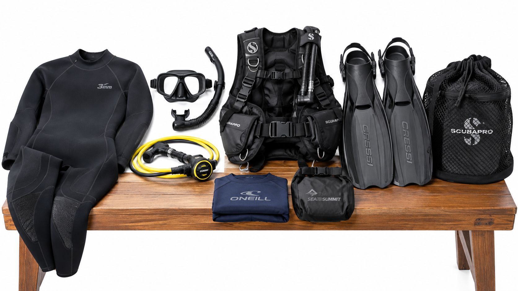 A complete set of scuba diving equipment laid out on a wooden bench against a white background.