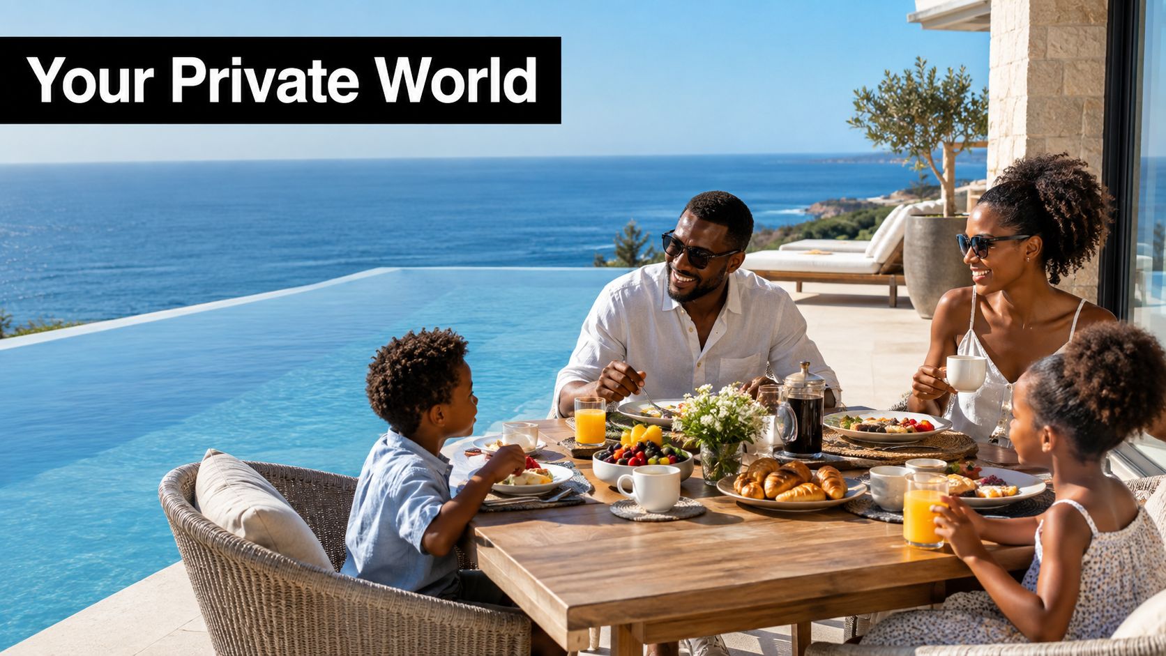 A happy Black family enjoys an outdoor breakfast on a terrace overlooking the blue ocean water.