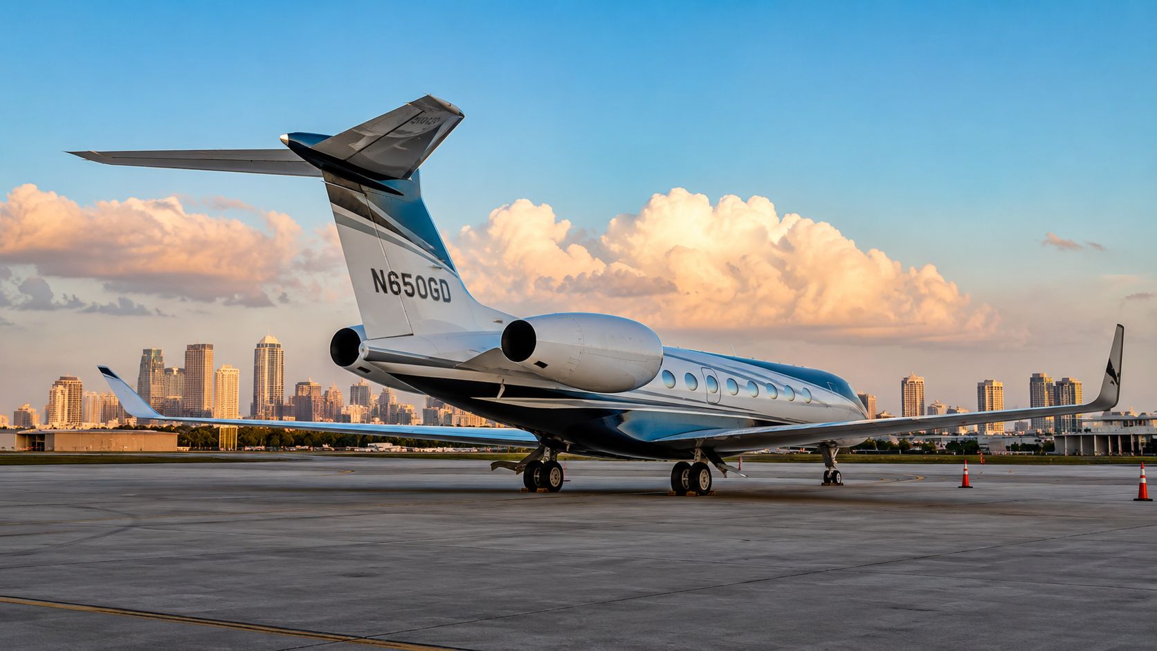 A luxurious private jet parked on an airport tarmac with the scenic city skyline in the background.