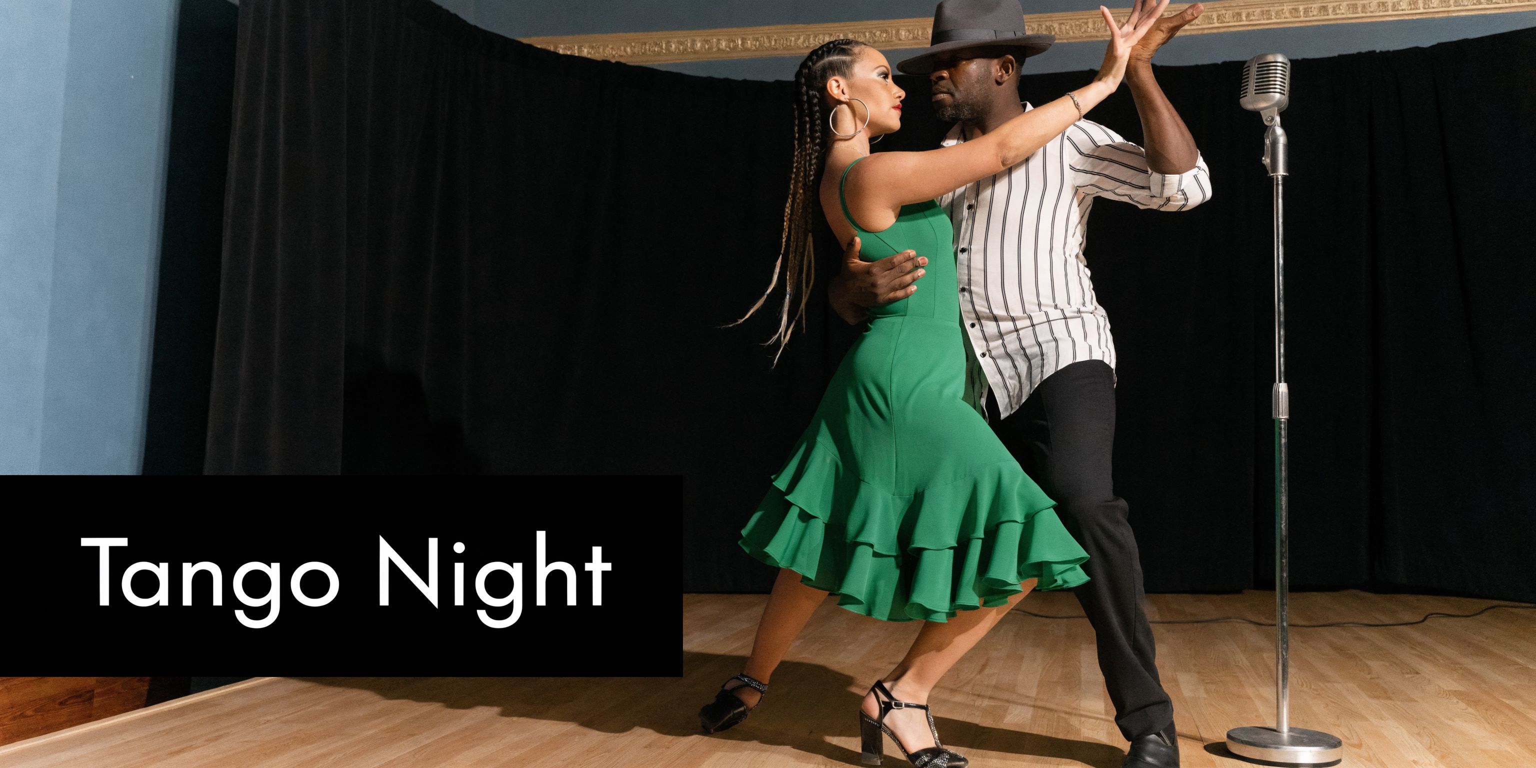 A professional couple dancing a passionate tango performance on a wooden stage during a festive event — Buenos Aires Tango Festival luxury travel | HauteBlack