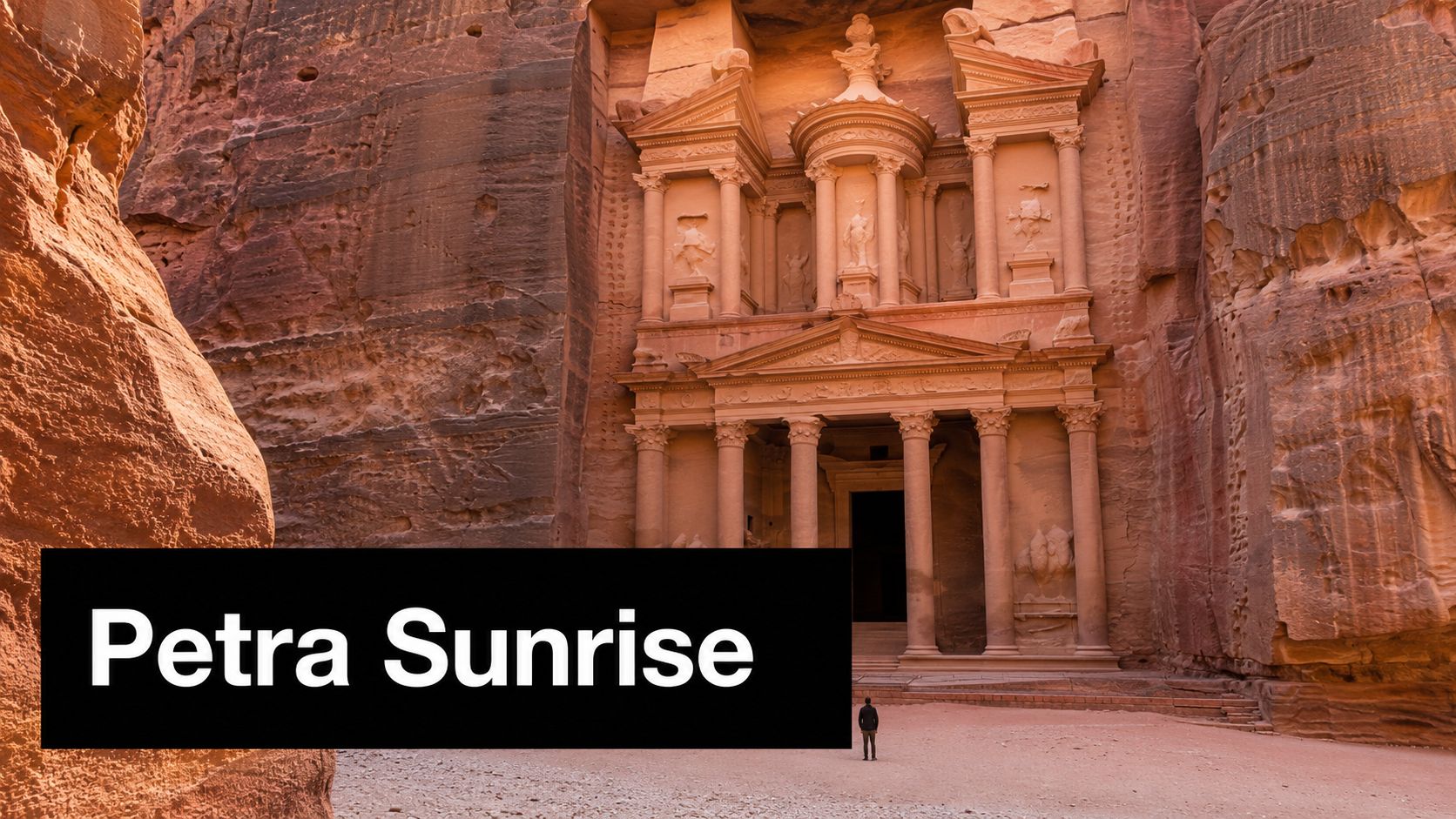 A solitary person standing in front of the historic Al-Khazneh temple carved into sandstone cliffs in Petra.