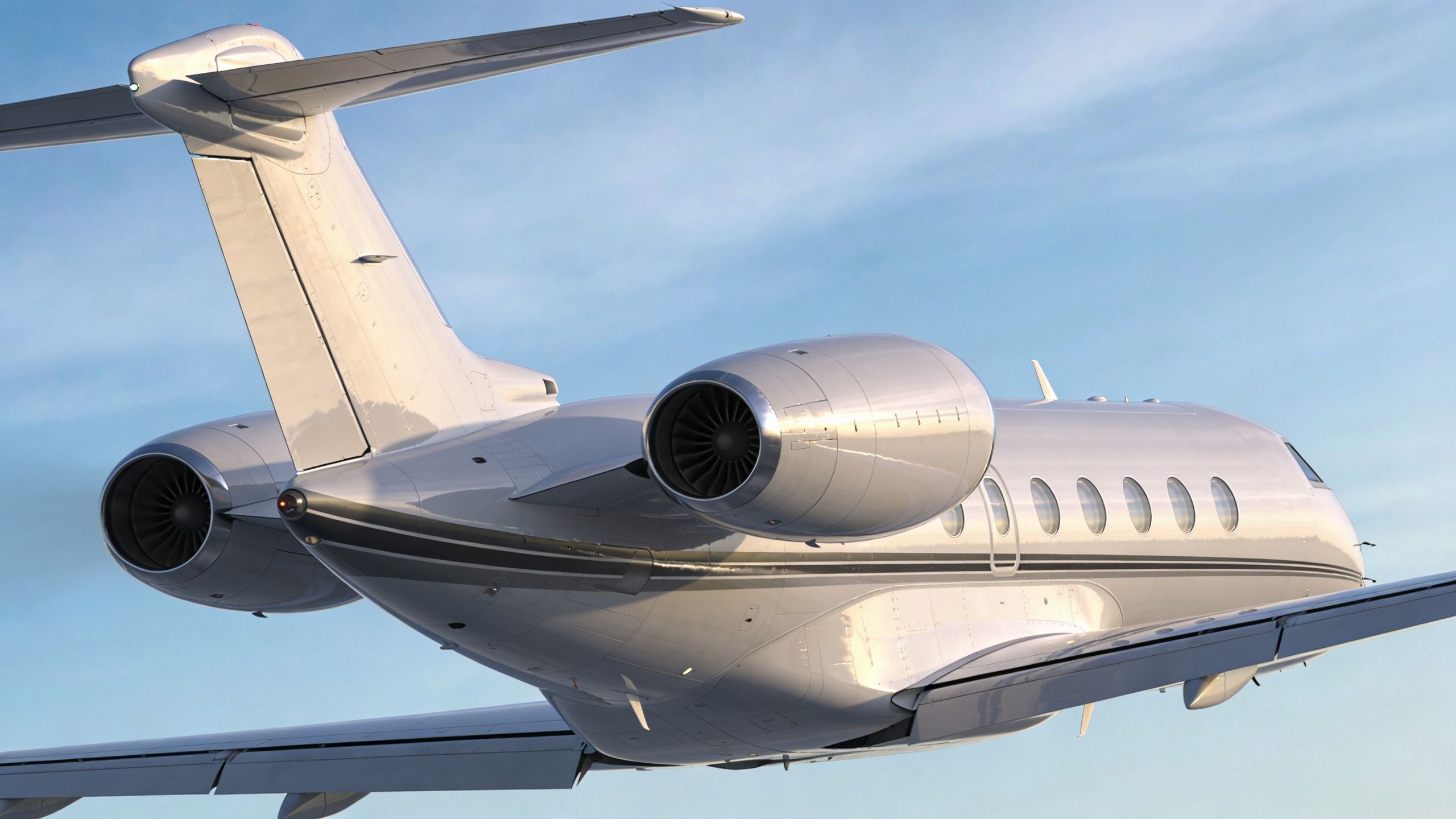 A sleek white private jet flying in the sky showing its rear mounted jet engines and tail.
