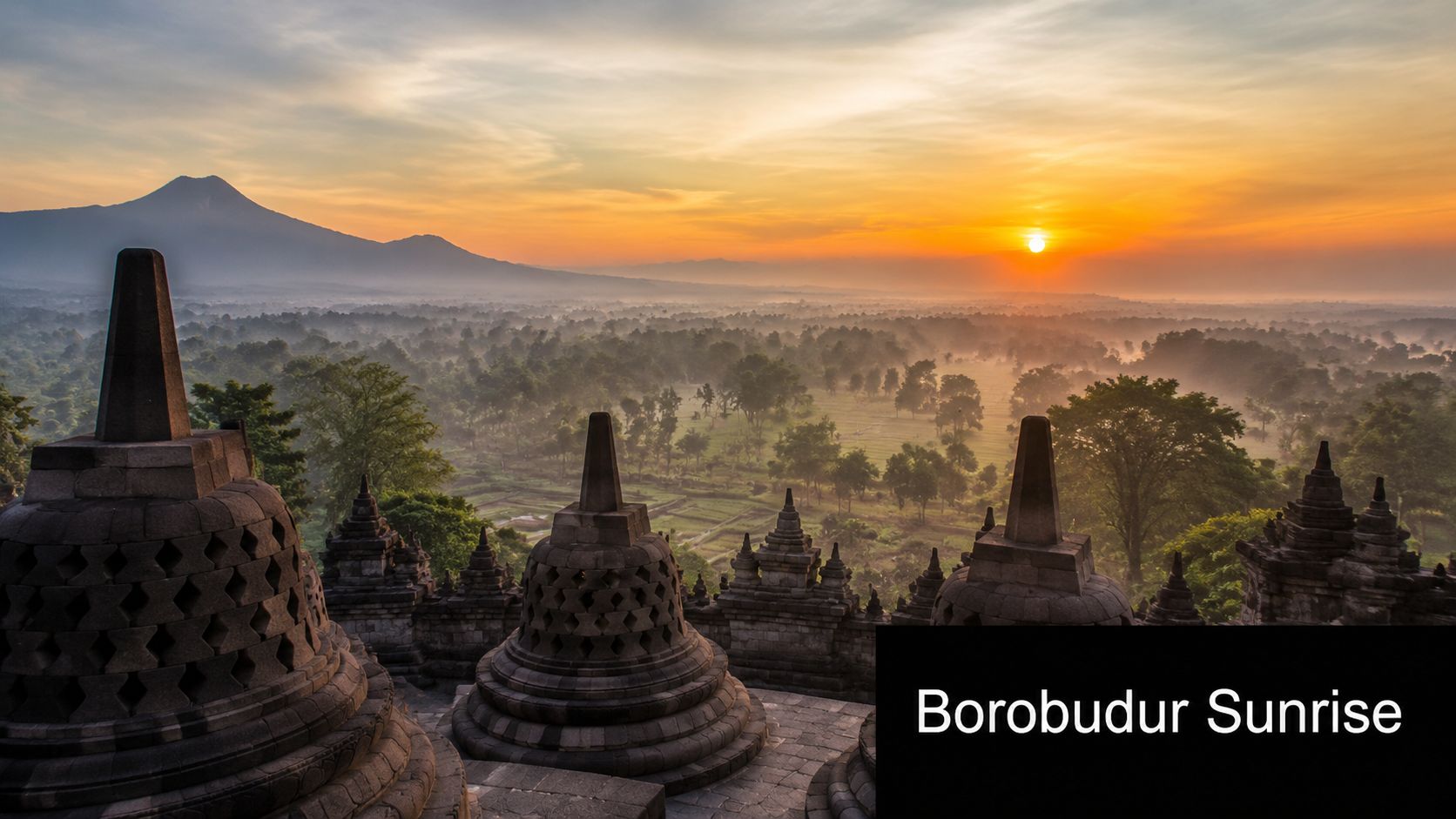 A breathtaking sunrise over the ancient Borobudur temple in Indonesia, featuring stone stupas against a misty mountain backdrop.
