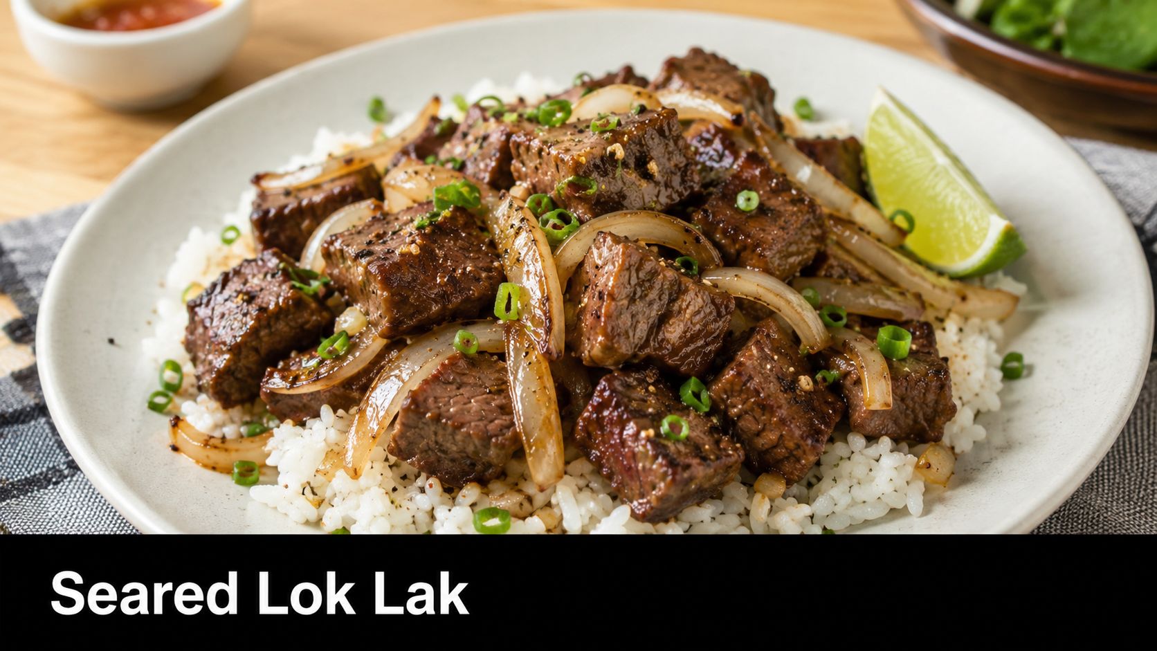 A delicious plate of Cambodian style Seared Lok Lak beef served over white rice with onions and lime.
