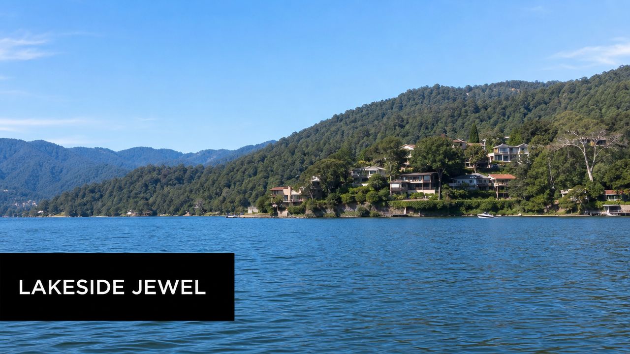 A picturesque view of luxury homes nestled along the lush green forested hills overlooking a calm lake.