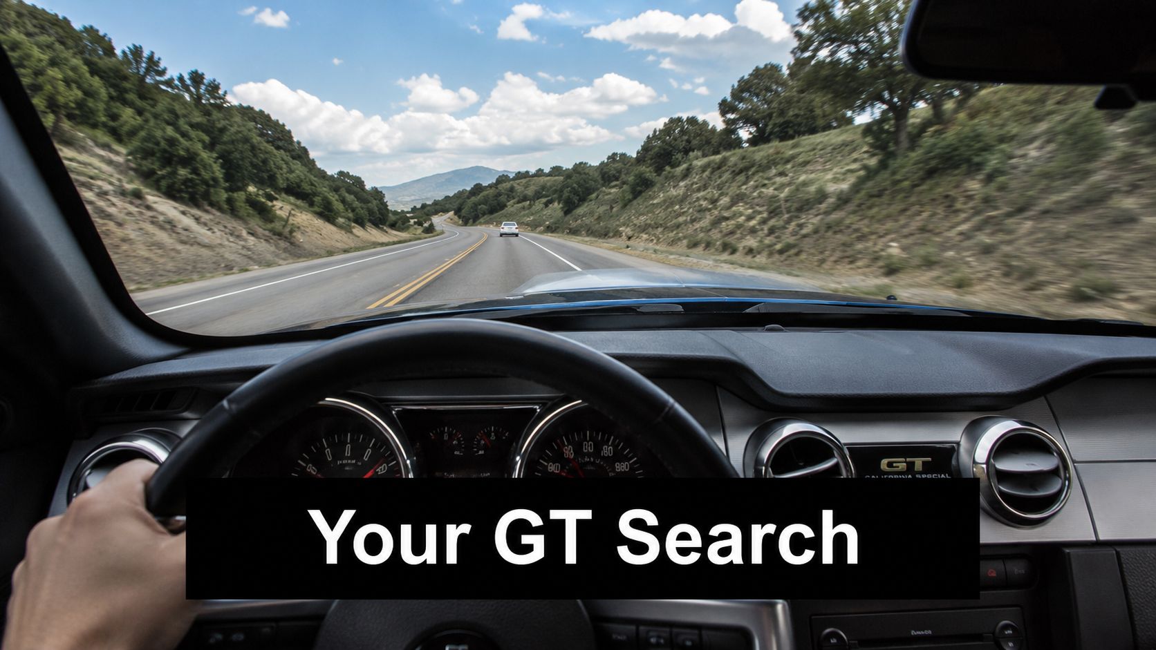 A first-person view from the driver seat of a Ford Mustang GT driving on a scenic highway.