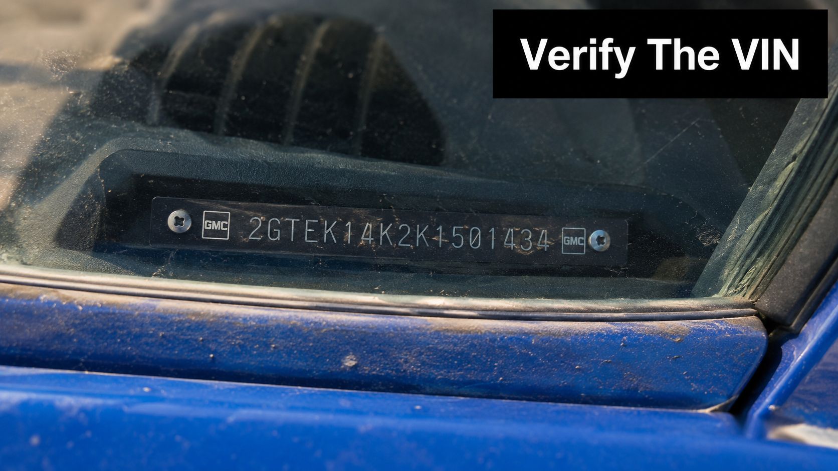 A close-up view of a GMC Sierra vehicle identification number plate on the dashboard.