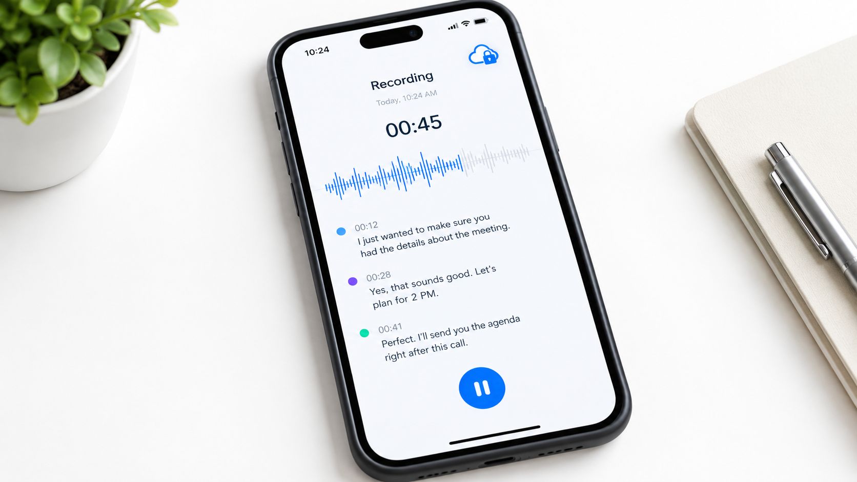 A smartphone displaying a voice recording app with live transcription of a business meeting on a desk.