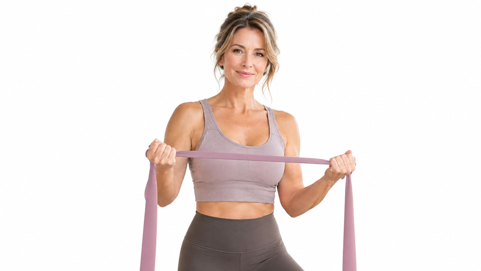 A fit woman exercising with a purple resistance band in front of a white background.