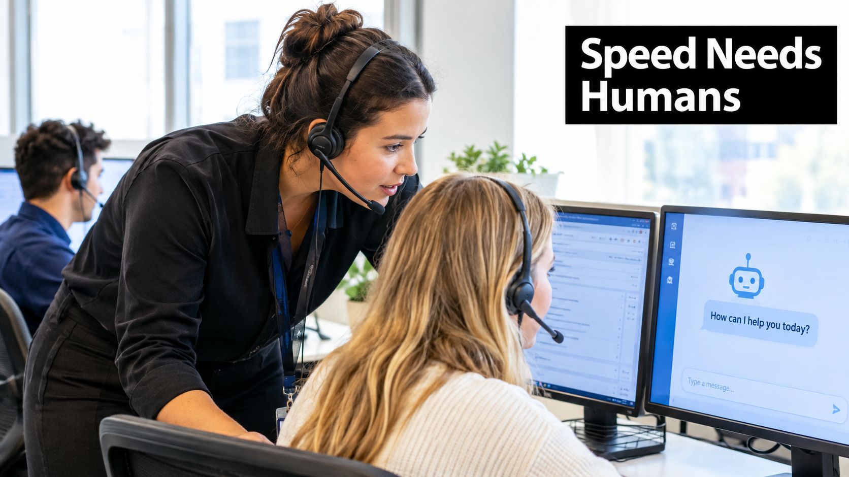 A customer service representative assisting a colleague at a desk with a chatbot on their computer screen.