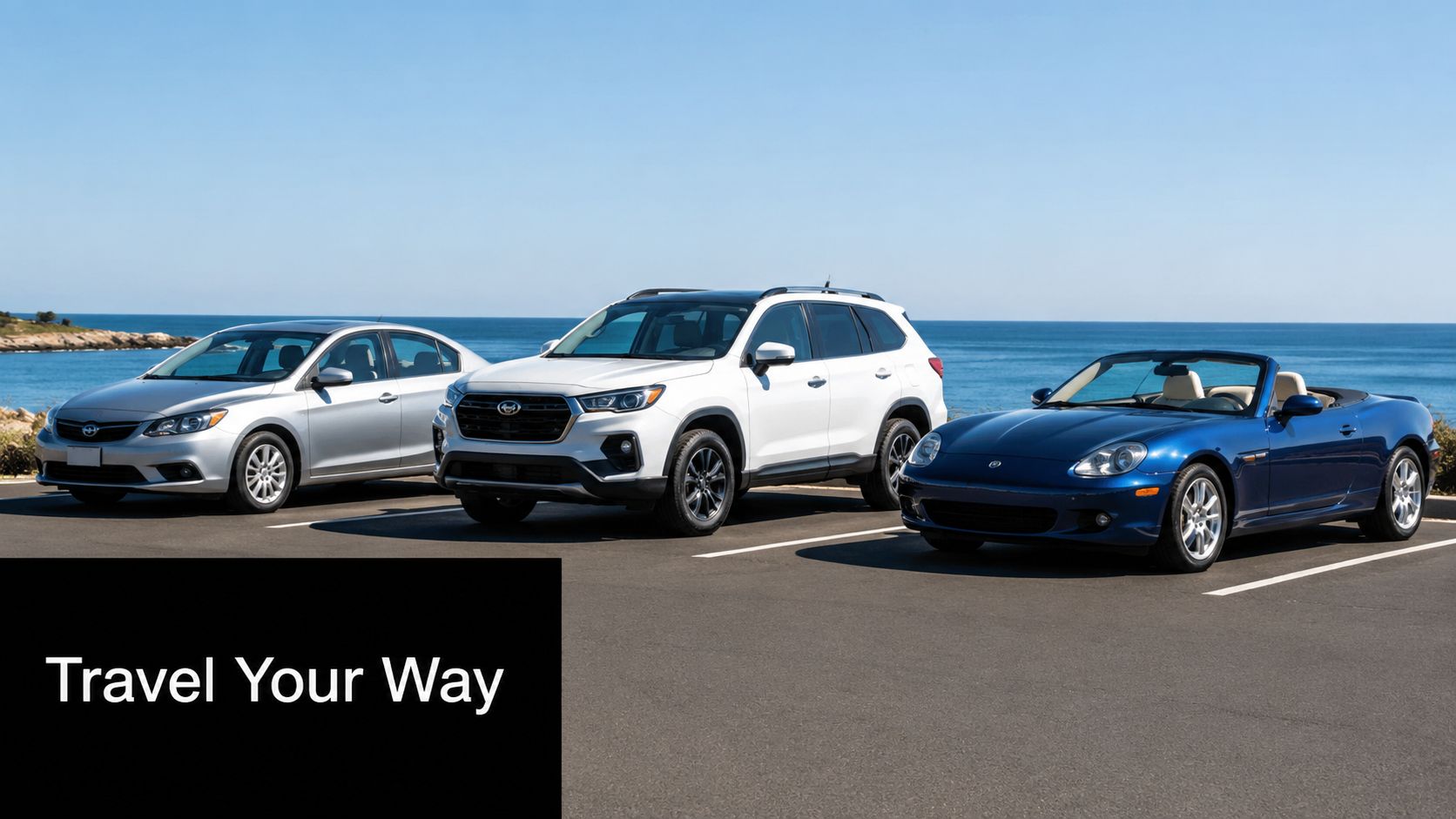 A silver sedan, white SUV, and blue convertible parked in a lot overlooking the blue ocean.
