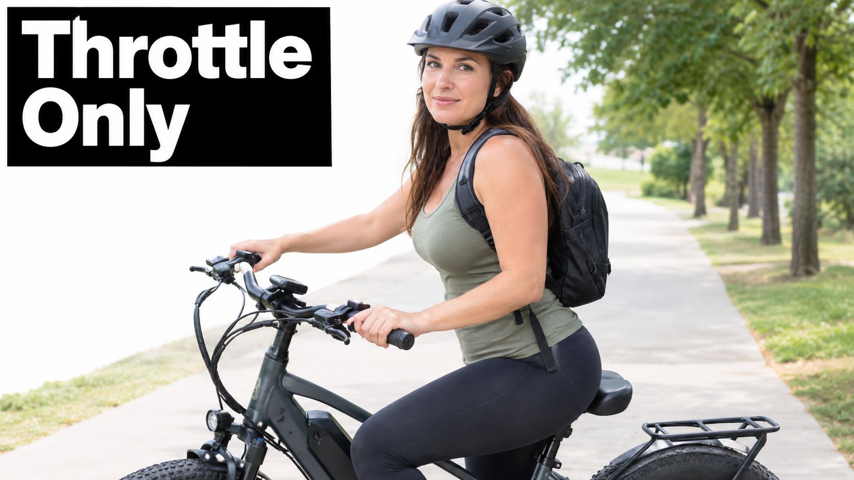 A fit woman wearing a helmet and backpack rides an electric bike on a paved path.