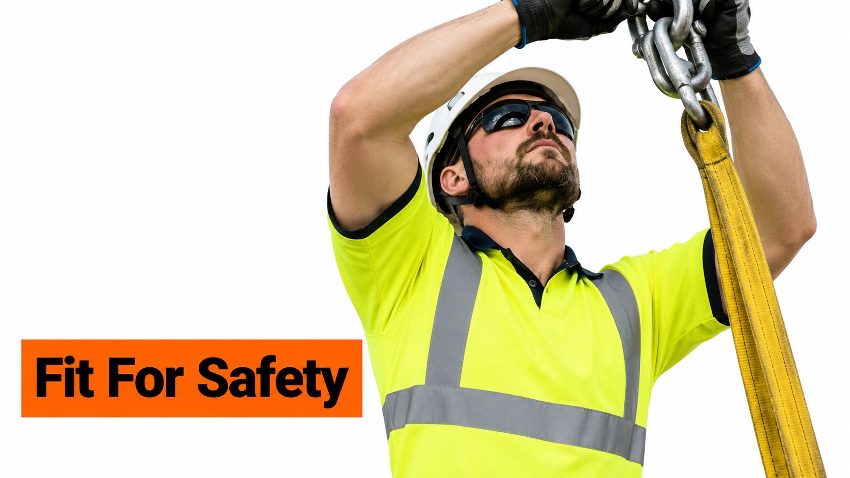 A construction worker wearing a high visibility shirt and hard hat inspects overhead rigging gear equipment.