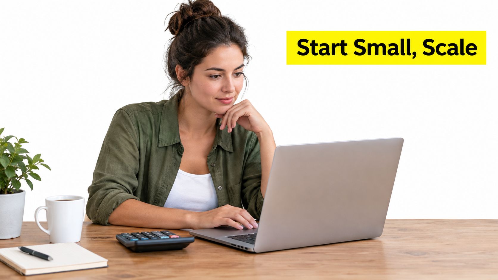 A woman working on a laptop at her desk with a cup of coffee and notebook.