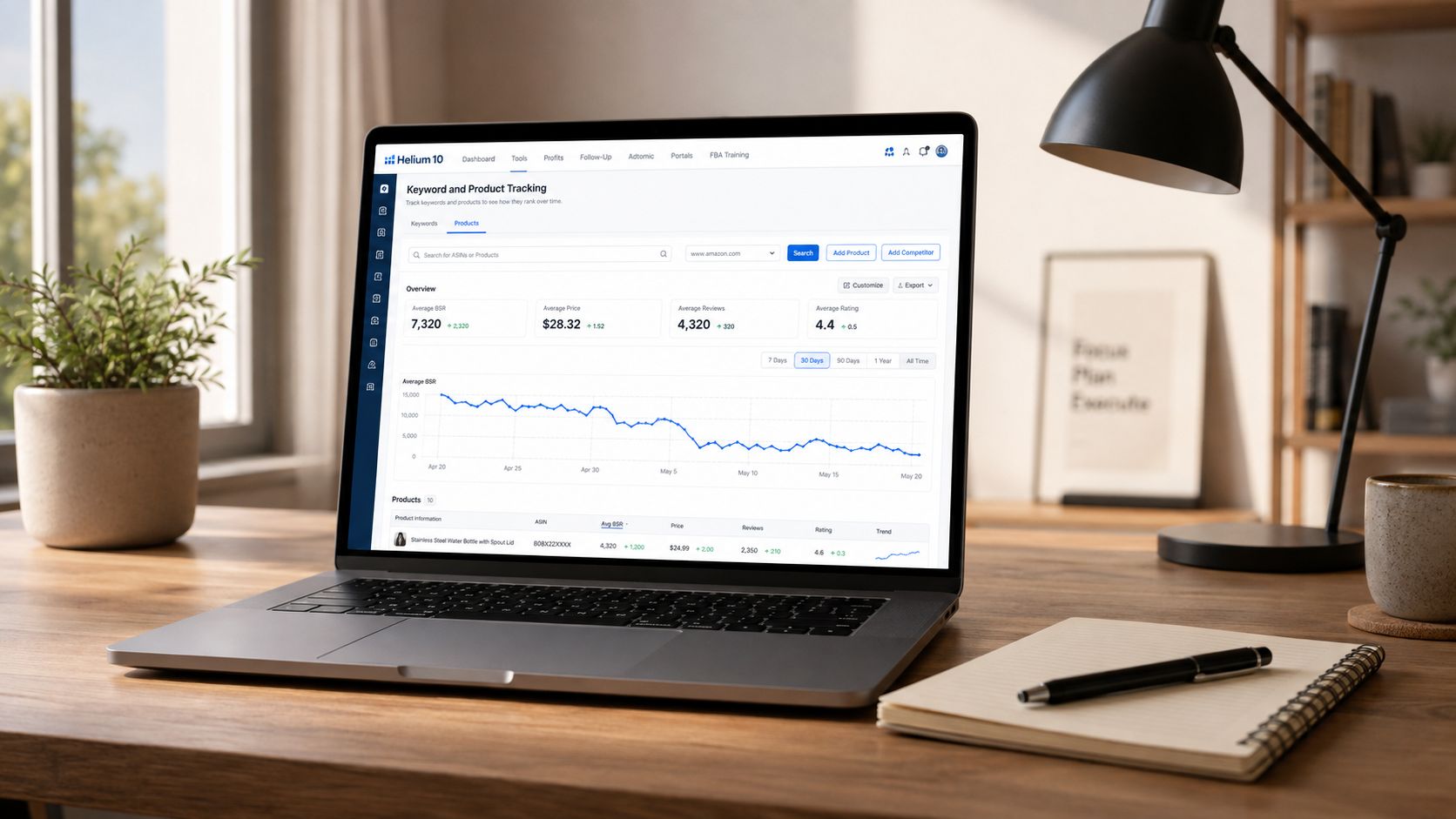 A laptop on a wooden desk displaying Helium 10's Keyword and Product Tracking dashboard for Amazon sellers.