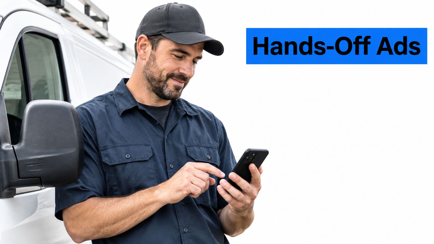 A smiling service technician in a uniform and cap checking his smartphone next to a van.