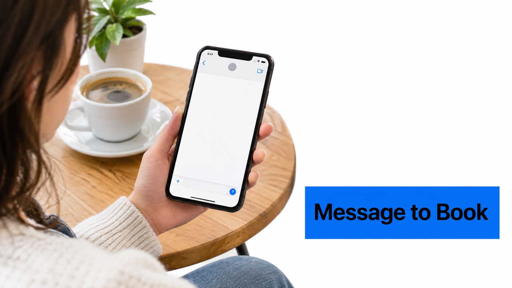 A woman holding a smartphone with a blank messaging screen while sitting at a coffee table.