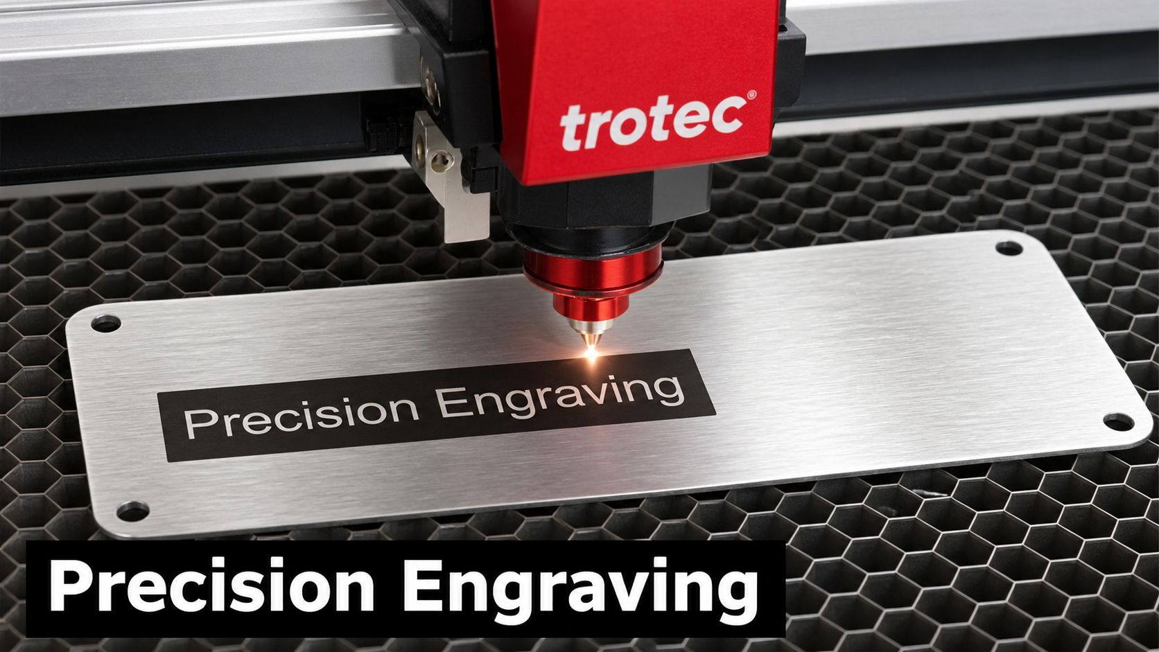 A Trotec laser machine engraving the words Precision Engraving onto a rectangular brushed aluminum industrial safety label.