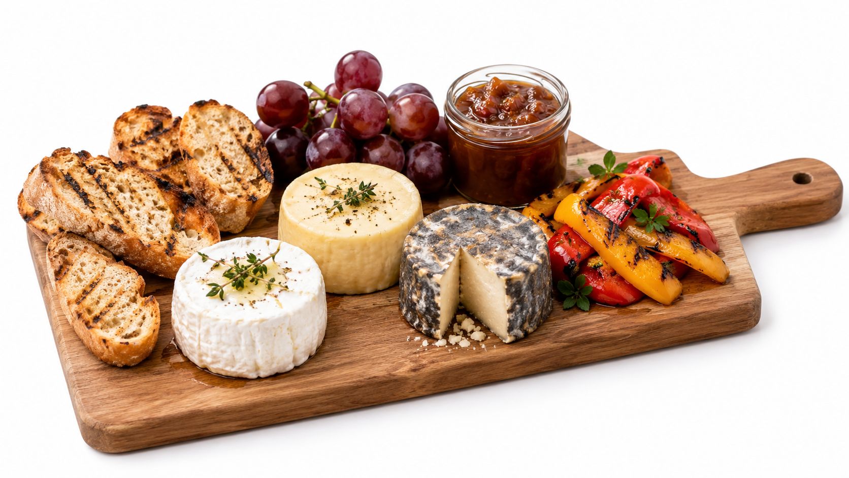 A wooden serving board featuring grilled bread, three varieties of gourmet cheese, fresh grapes, and roasted vegetables.