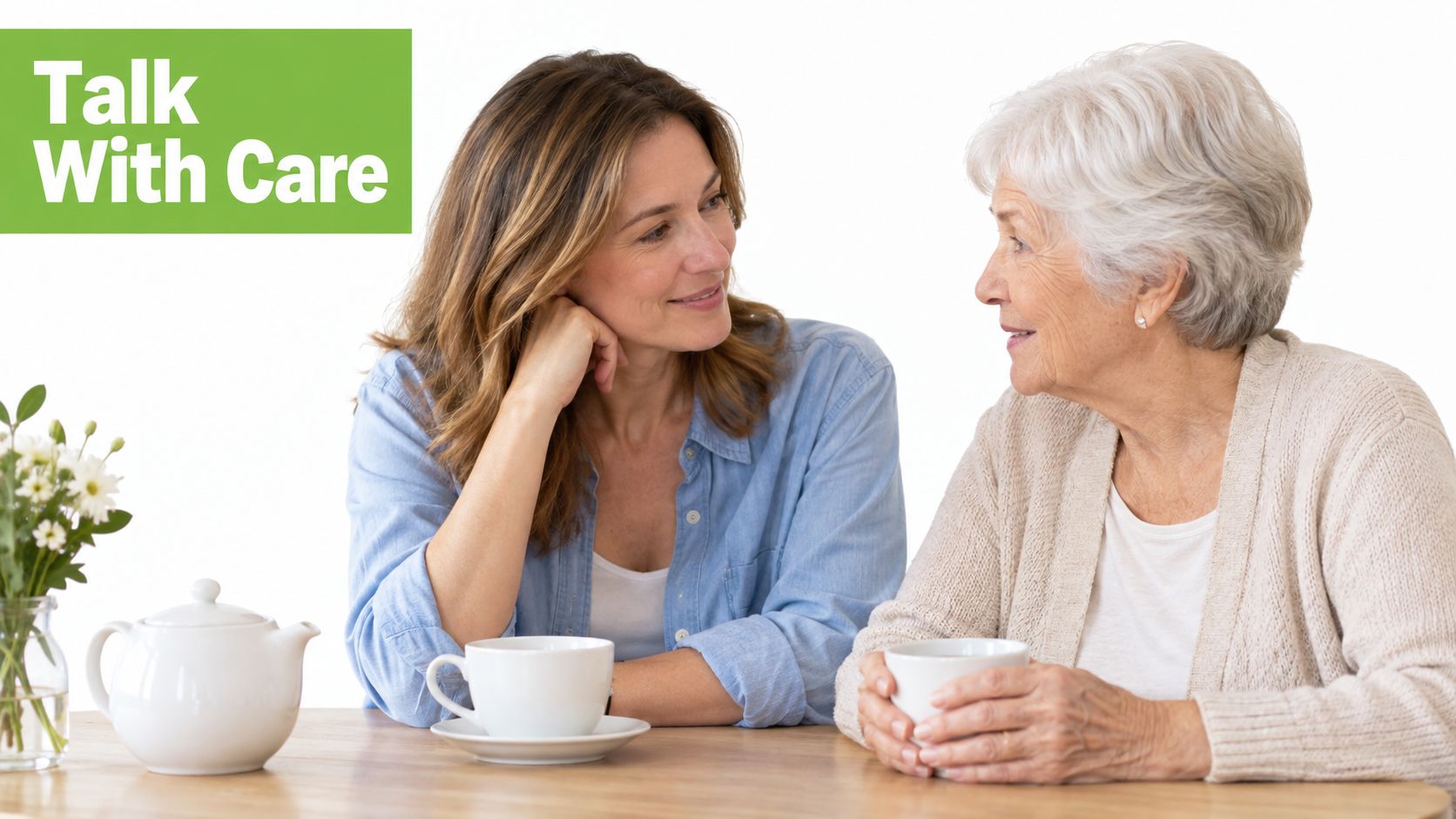 A younger woman sitting and having a caring, supportive conversation with an elderly woman over tea.