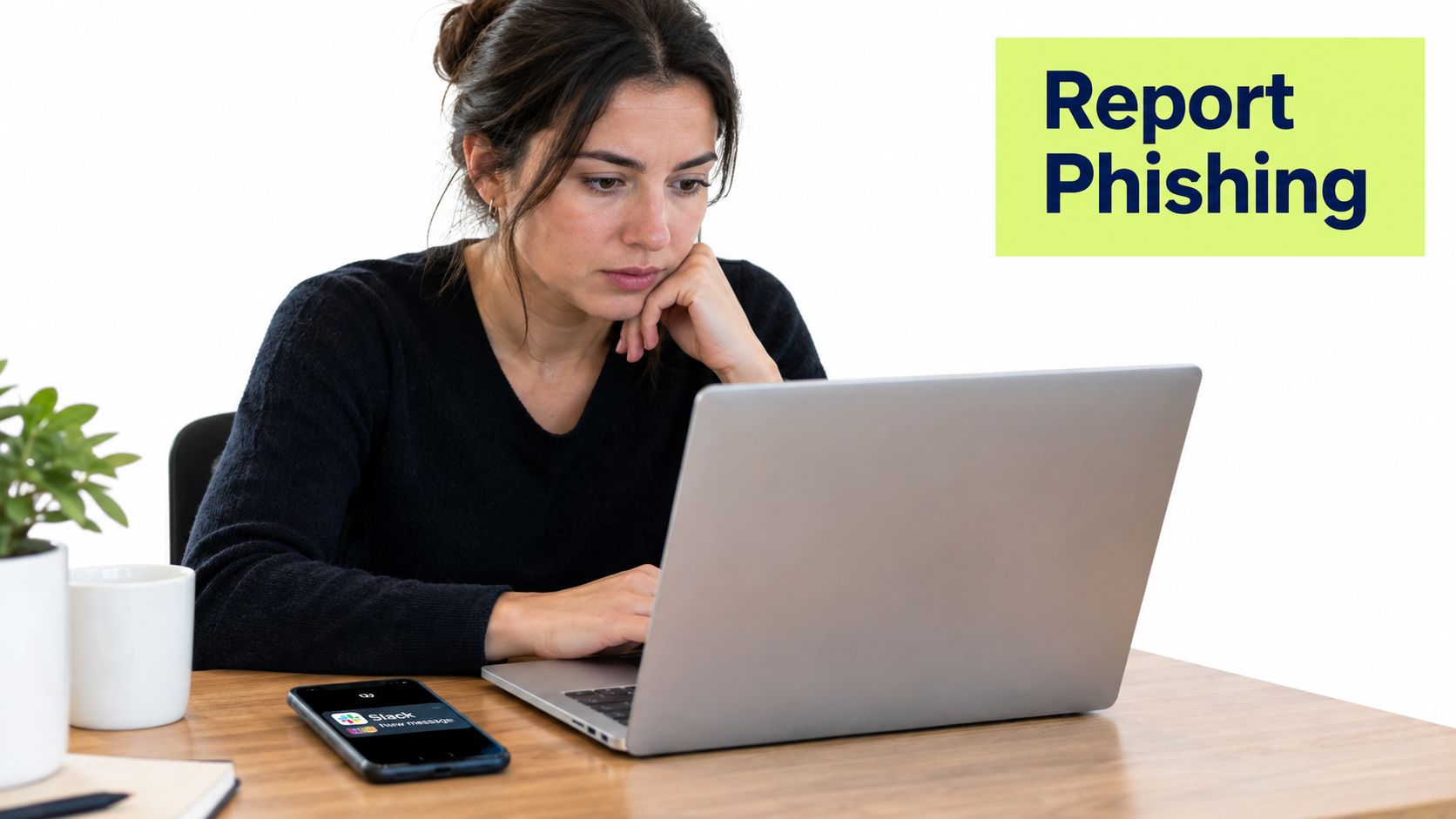 A concerned woman looks at her laptop while sitting at a desk with a smartphone nearby.