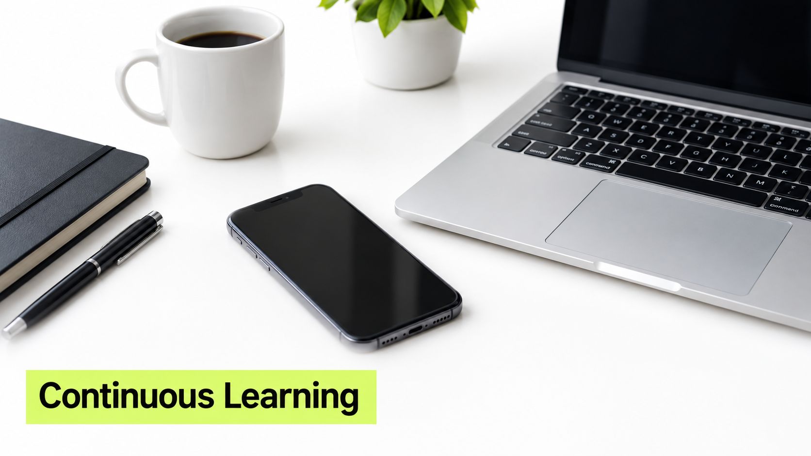 A minimalist workspace featuring a laptop, smartphone, coffee cup, and notebook with the text Continuous Learning.