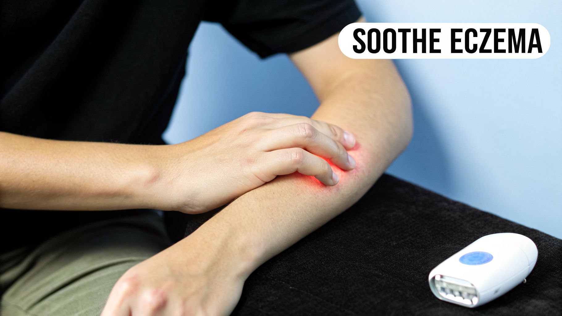 A person scratches a red, inflamed area on their forearm, indicating eczema, with a light therapy device nearby.