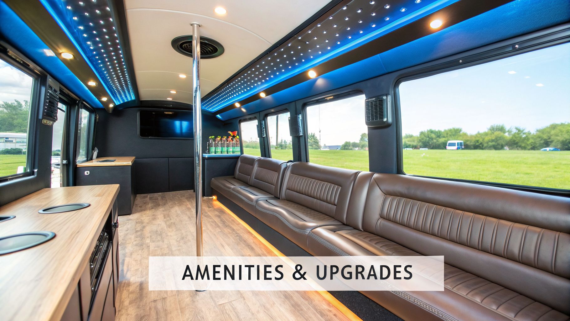 Spacious party bus interior featuring brown leather seating, vibrant blue LED lighting, a bar, and dance pole.