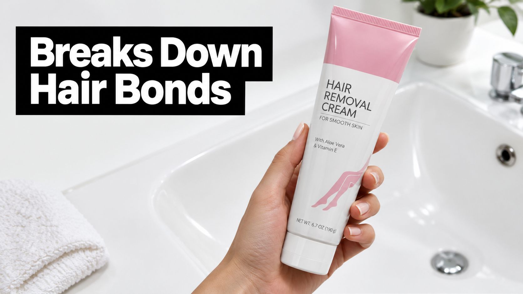 A hand holding a tube of hair removal cream in a bathroom with a sink and towel.