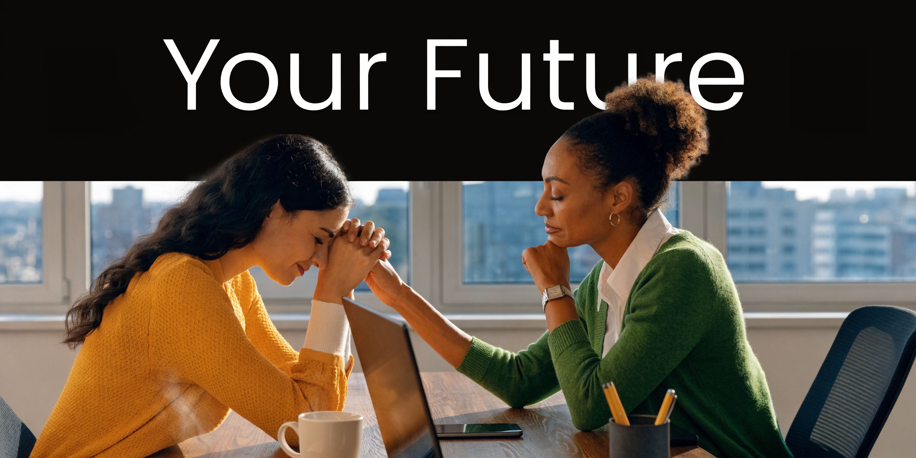 A professional woman in a green cardigan comforts a concerned woman sitting at a desk together.
