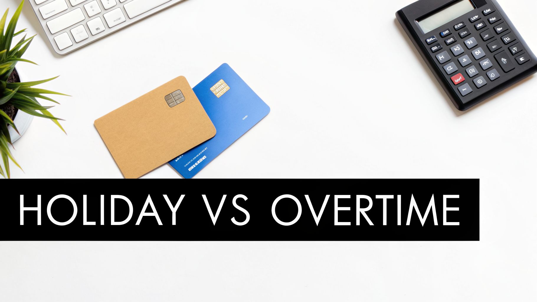 Overhead view of a desk with calculator, keyboard, plant, credit cards, and 'HOLIDAY VS OVERTIME' text.
