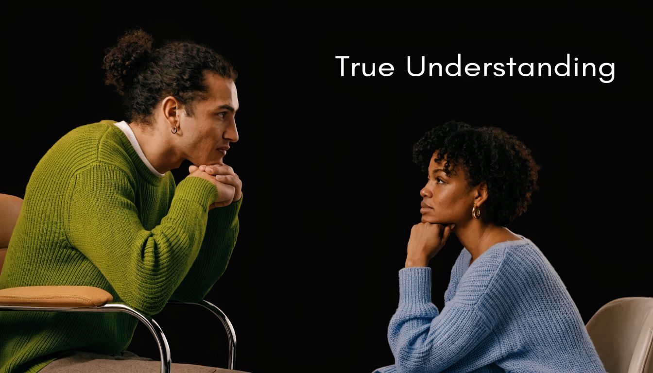 A young man and woman sitting in chairs facing each other, looking at one another with understanding.
