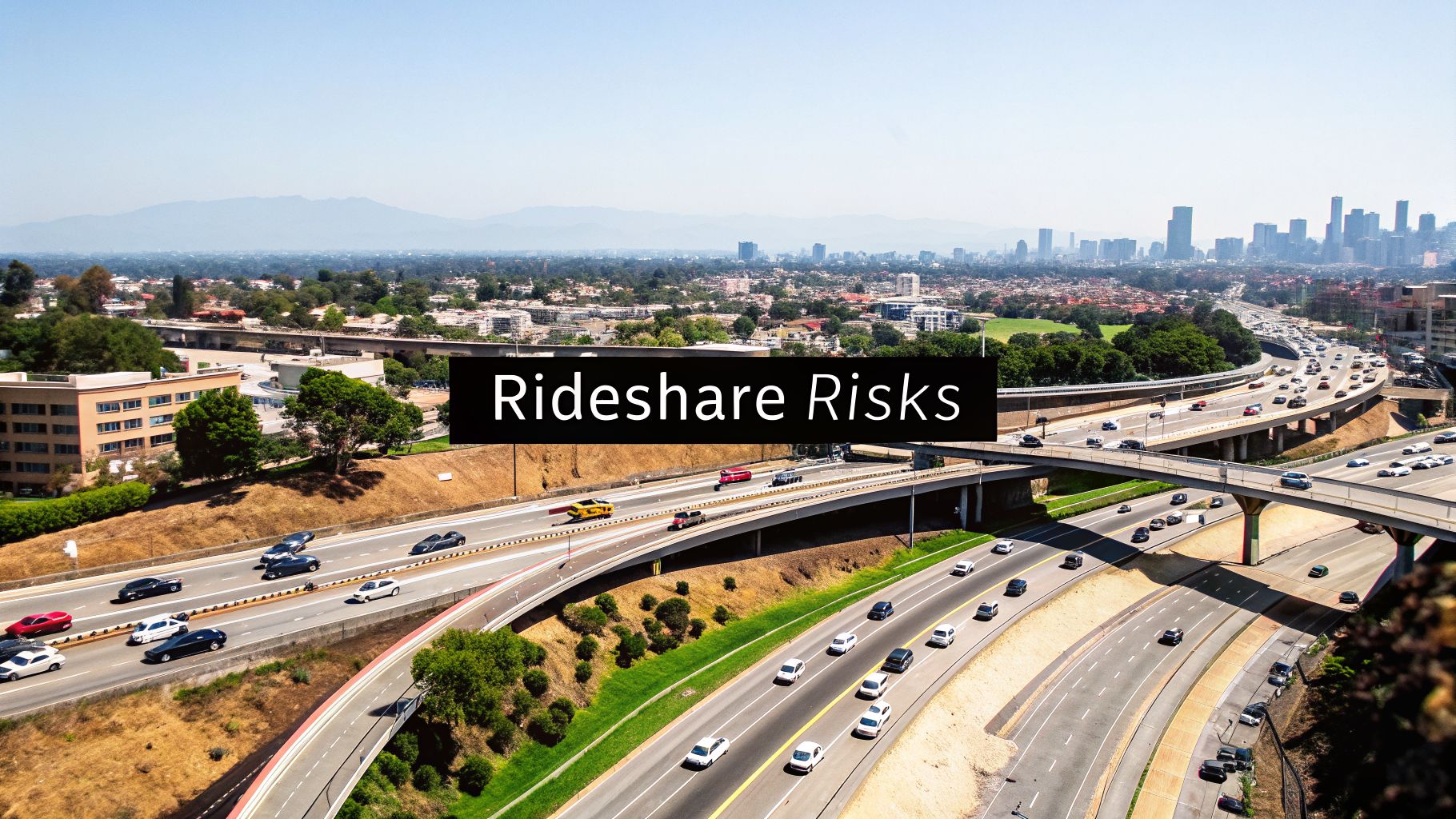An aerial view of a busy Los Angeles freeway intersection with cars, beneath a clear sky.