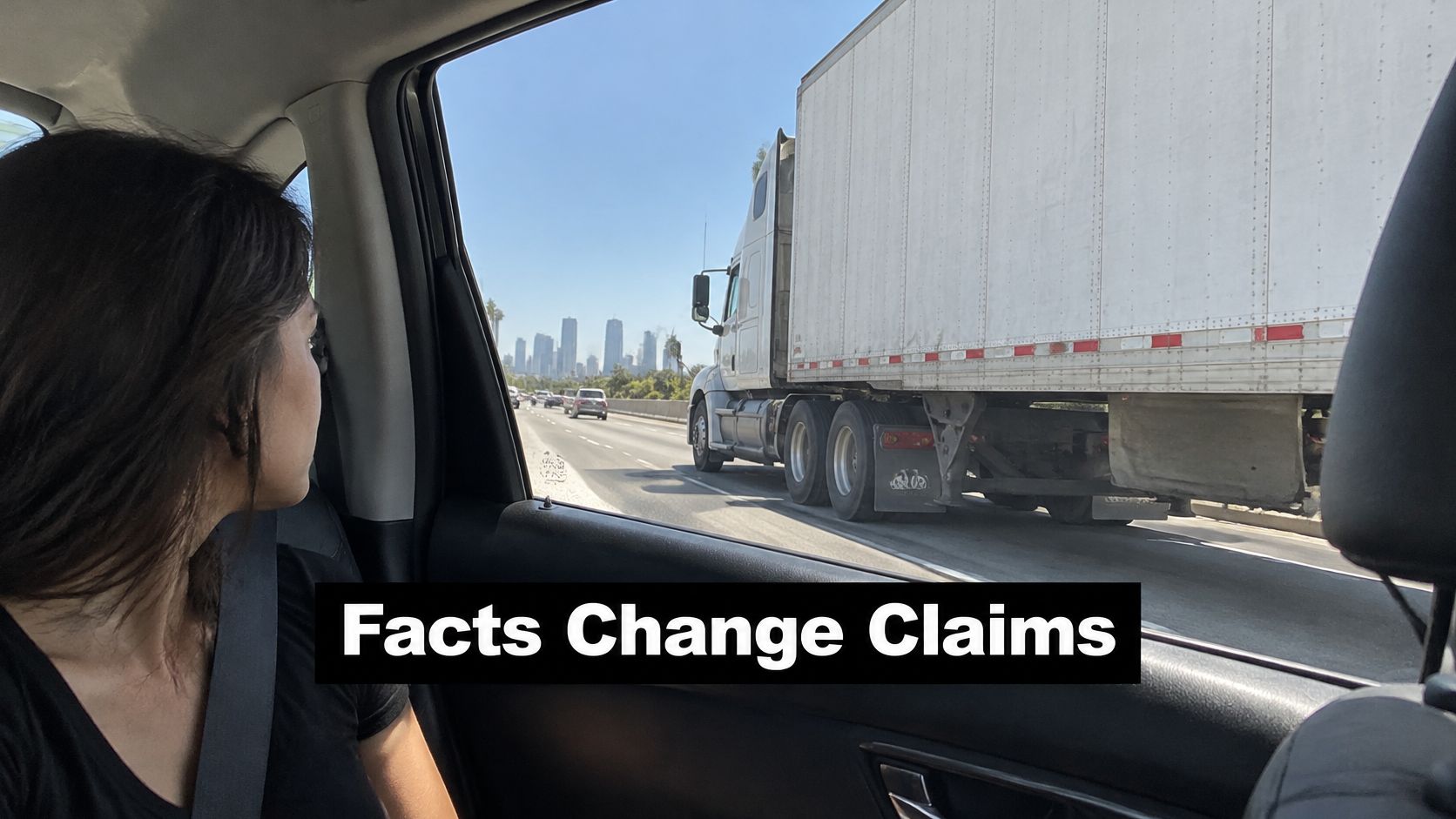 A woman looks out a car window at a semi truck driving on a highway near Los Angeles.